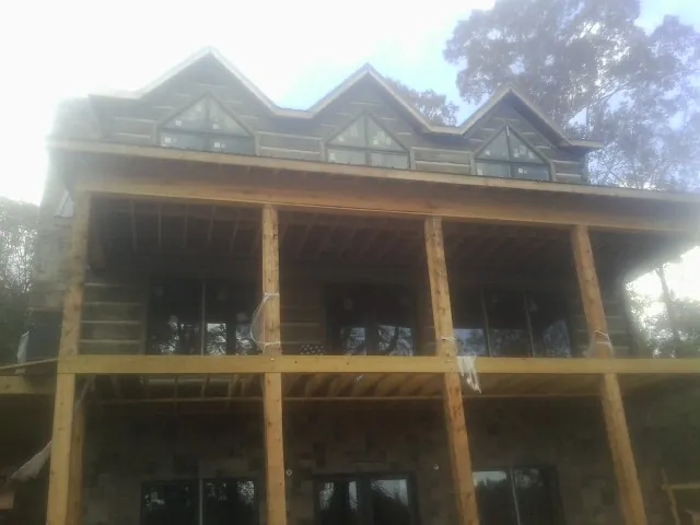 Dormers and porch framing on a large log home under construction — Roof Coating work by our crew in Marshalltown