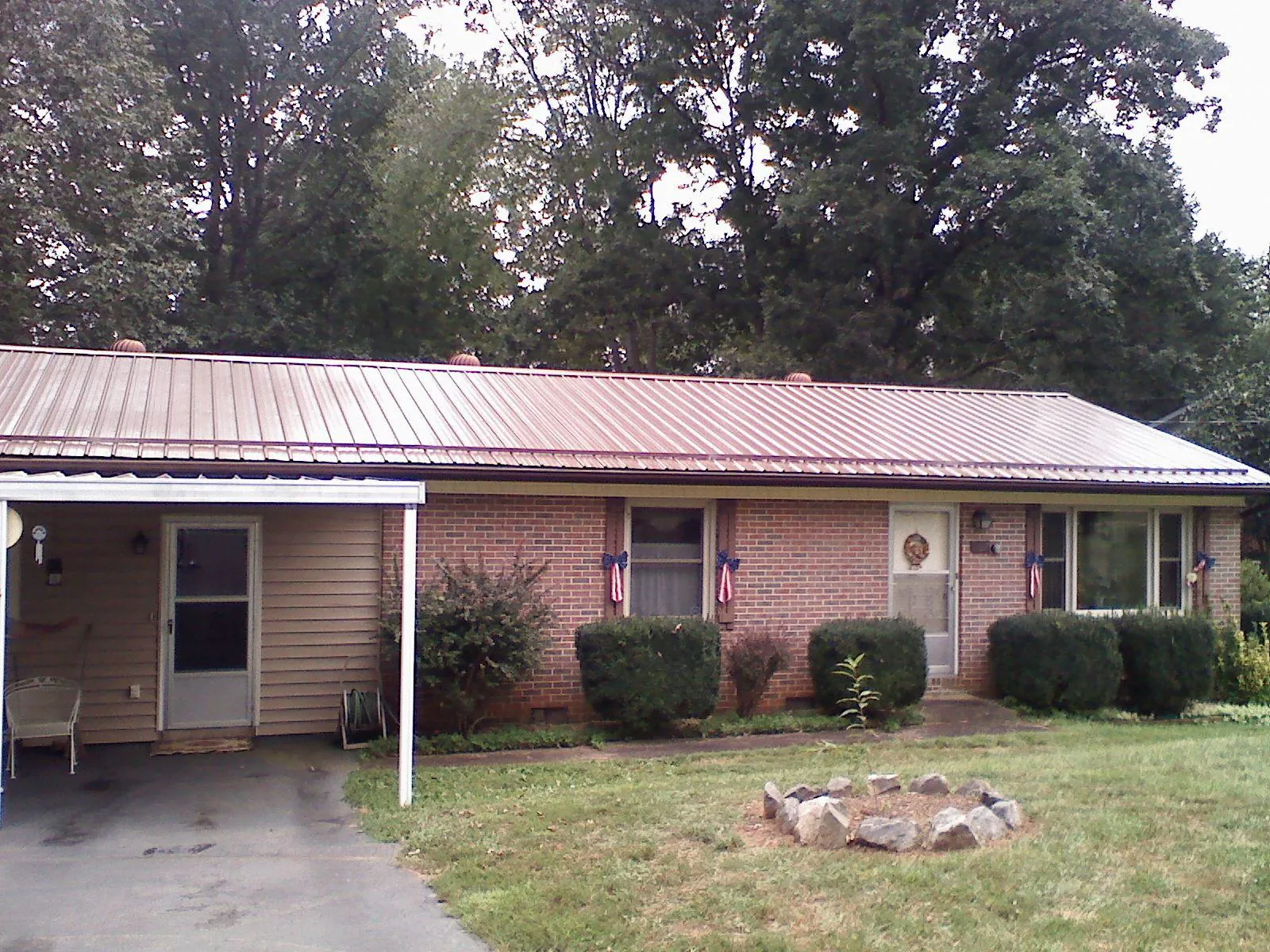 Bronze metal roof and carport on a brick ranch home — Roof Repair work by our crew in Marshalltown
