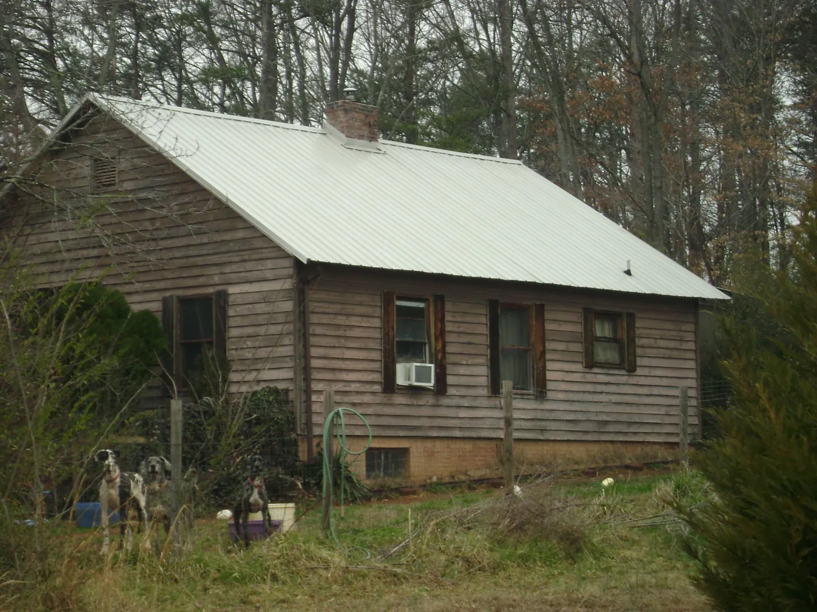 White metal roof on an old wood sided farmhouse, from a Metal Roof Installation job in Marshalltown
